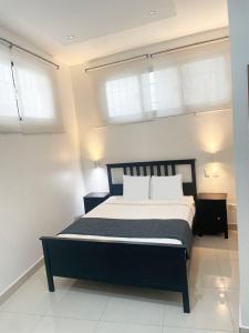 a bedroom with a large bed with two windows at City Caribbean Hotel Boutique in Santo Domingo