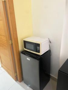 a microwave sitting on top of a refrigerator at City Caribbean Hotel Boutique in Santo Domingo