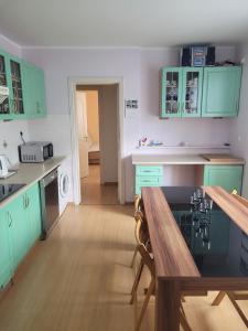 cocina con armarios verdes y mesa de madera en Gdańsk Cozy Loft, en Gdansk