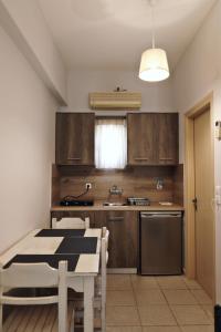 a kitchen with wooden cabinets and a table and a sink at Niriides rooms in Kionia +33 photos