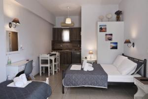 a living room with a bed and a kitchen at Niriides rooms in Kionia