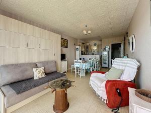 a living room with a couch and a table at Studio Mer & Soleil-3 by Interhome in Saint-Brévin-lʼOcéan