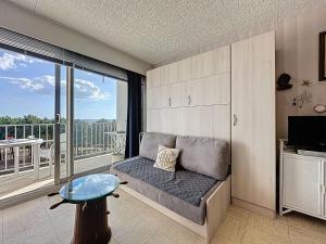 a living room with a couch and a large window at Studio Mer & Soleil-3 by Interhome in Saint-Brévin-lʼOcéan