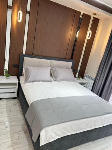a bedroom with a large bed with white pillows at Туркестан VIP КАРАВАН in Türkistan