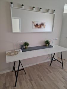 uma secretária branca com plantas num quarto em The Oasis - Heart of Riga em Riga mais 9 fotografias