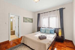 リヴィエール・ノワールにあるNumi Bay - Amazing Apartment with Morne Viewの青い枕と窓のあるベッドのある寝室