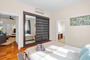 リヴィエール・ノワールにあるNumi Bay - Amazing Apartment with Morne Viewのベッドルーム(鏡付きの大きな白いベッド1台付) +21枚の写真