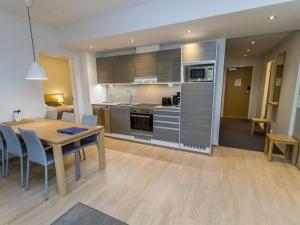 Una cocina y un comedor con mesa y sillas. en Holiday Home Ruka ski chalets ii huoneisto 2605 by Interhome, en Rukatunturi 