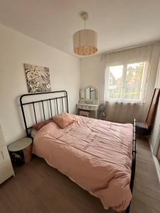 a bedroom with a large bed with a pink blanket at Agréable maison de ville dans quartier calme in Bourges