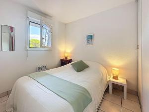 ein kleines Schlafzimmer mit einem Bett und zwei Lampen in der Unterkunft Apartment L'Orée du Golf-3 by Interhome in Pornic + 22 Fotos