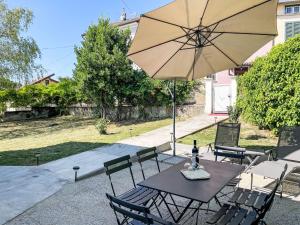 Una mesa y sillas con una sombrilla en un patio. en Holiday Home Guest House Viotti by Interhome, en Castel Rocchero