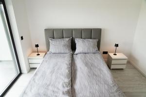 a bedroom with two beds with white sheets and lamps at Apartament 3 z ogródkiem in Sieniawa Żarska