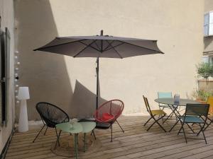 a patio with a table and chairs and an umbrella at Le Baron terrasse et parking cœur de Castres in Castres +9 photos