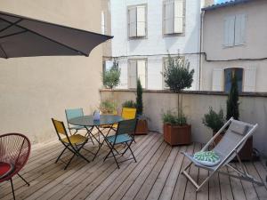 a patio with a table and chairs on a deck at Le Baron terrasse et parking cœur de Castres in Castres