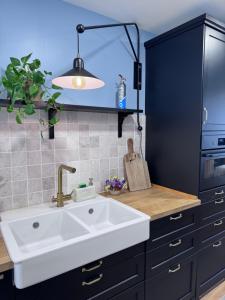 Una cocina con un fregadero blanco y un armario negro. en Casa Paz Lugo, en Lugo 29 fotos más
