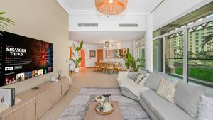 迪拜The Palm Jumeirah Shoreline Living l 3BR Elegant Resort Style Entire Home l Beach Access的带沙发和电视的客厅