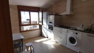 a kitchen with a washing machine and a window at Habitaciones para dormir in Vadocondes +28 photos