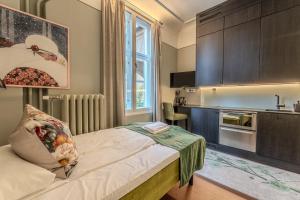 a small bedroom with a bed and a kitchen at The Apartments Company - The Sweet in Oslo