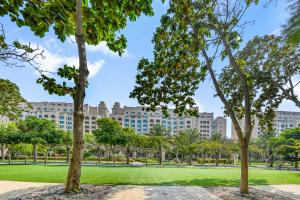 迪拜The Palm Jumeirah Shoreline Living l 3BR Elegant Resort Style Entire Home l Beach Access的大型建筑前的公园