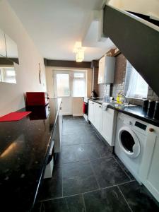 een grote keuken met een wasmachine en droger. bij 4 Bedroom Rayleigh Town House in Rayleigh
