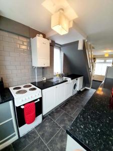 een keuken met een fornuis en een spoelbak bij 4 Bedroom Rayleigh Town House in Rayleigh