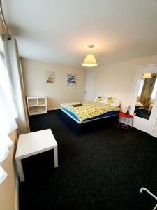 een slaapkamer met een bed en een tafel erin bij 4 Bedroom Rayleigh Town House in Rayleigh +2 foto's