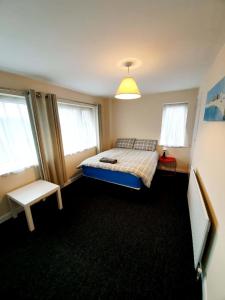 een slaapkamer met een bed en twee ramen bij 4 Bedroom Rayleigh Town House in Rayleigh