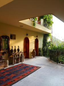 a house with a patio with a rug and a balcony at Emel Pension in Güzelçamlı