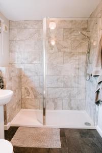 a shower with a glass door in a bathroom at Romantic Country Cottage with Private Hot Tub in Rowde +25 photos