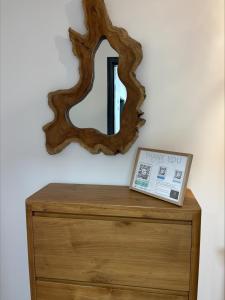 a mirror on top of a wooden dresser with a drawer at A Isula Paradisu - Classé 4 étoiles in LʼÎle-Rousse