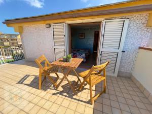 drewniany stół i 2 krzesła na patio w obiekcie Attico casalnuovese w mieście Casalnuovo di Napoli