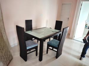 mesa de comedor y sillas con encimera de cristal en GG Homes, en Udaipur