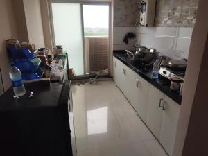 Una cocina con gabinetes blancos y una encimera negra. en GG Homes, en Udaipur