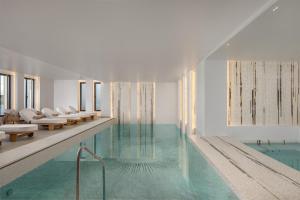 a swimming pool with white chairs and a swimming pool at Vione Paros in Ambelas +26 photos