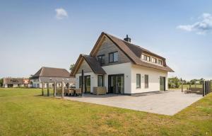 a large white house with a patio in a field at F Luxe Villa Bouwlust 10 Pers in De Cocksdorp