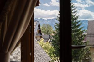 a window with a view of a mountain at Willa Podhalanka Jacuzzi & sauna - drewniany dom dla 20 osób in Biały Dunajec