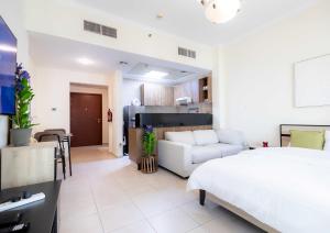 Un dormitorio con una cama blanca y una sala de estar. en Burj Al Nujoom Downtown Dubai Mall & Burj Khalifa, en Dubái 66 fotos más