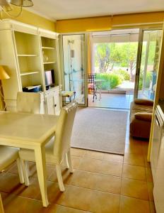 una sala da pranzo con tavolo e sedie e un soggiorno di Le Papyrus -T2 Domaine Pierres et Vacances "Les Restanques du golf de Saint Tropez" à Grimaud a Grimaud