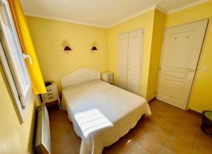 una camera con letto bianco e pareti gialle di Le Papyrus -T2 Domaine Pierres et Vacances "Les Restanques du golf de Saint Tropez" à Grimaud a Grimaud Altre 18 foto