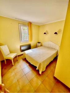 una camera da letto con un letto, una sedia e una finestra di Le Papyrus -T2 Domaine Pierres et Vacances "Les Restanques du golf de Saint Tropez" à Grimaud a Grimaud