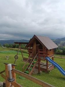 un parque infantil de madera con un tobogán y una casa en Apartament u Krupy, en Murzasichle