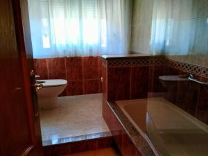 ein Badezimmer mit Badewanne, Toilette und Waschbecken in der Unterkunft Chalet con piscina in Tabagón + 14 Fotos