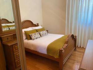 ein Schlafzimmer mit einem Bett und einem Spiegel in der Unterkunft Chalet con piscina in Tabagón