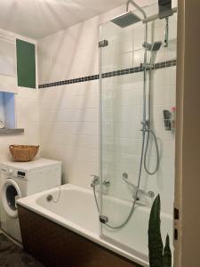 a bathroom with a shower and a washing machine at Ferienwohnung "Casa Schulzini" im Marburger Südviertel in Marburg an der Lahn +6 photos