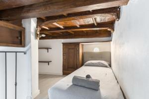 a large bed in a room with wooden ceilings at White APT - Duomo - 6 posti in Milan