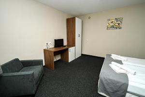 a hotel room with a couch and a bed and a desk at Complex Magiyata na Rila in Rilski Manastir