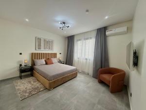 a bedroom with a bed and a chair at Beautiful apartment at point E, Dakar in Dakar +12 photos