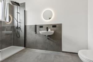 a bathroom with a sink and a shower at Nordbrise by BohnApartments-Modernes Apartment-Zentrum Diepholz-Parken kostenfei in Diepholz +23 photos