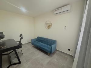 a living room with a blue couch and a piano at Sublime appartement avec Piscine, 2 chambres au Point E, Dakar in Dakar +13 photos