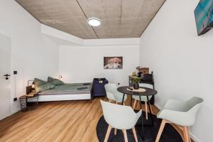a room with a bed and a table and chairs at Nordbrise by BohnApartments-Modernes Apartment-Zentrum Diepholz-Parken kostenfei in Diepholz